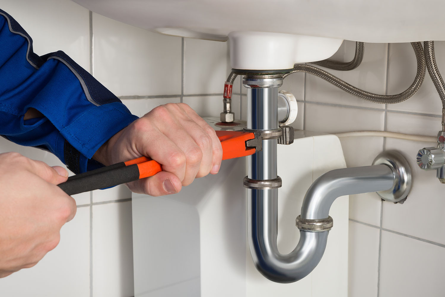 Close-up Of Male Plumber Repairing Sink In Bathroom